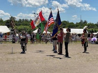 a group of people standing in a field with flags