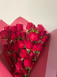 a bouquet of red roses in a red box