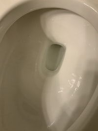 a close up of a toilet bowl with a hole in it