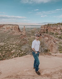a man standing on top of a cliff in the desert