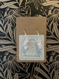 a pair of rose quartz earrings in a cardboard box