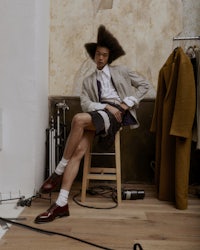 a man sitting on a stool in a room