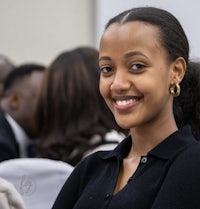 a young african woman smiling at a conference