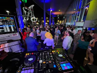 a group of people standing around a dj at a night event
