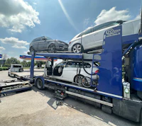 a car is being transported on the back of a truck