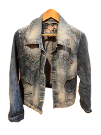 a women's denim jacket hanging on a hanger