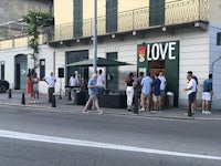 a group of people standing in front of a building with a sign that says love