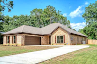 a brick home in the middle of a grassy yard