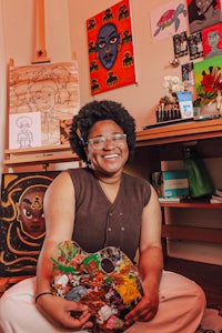 a woman holding a piece of art