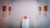 a group of orange telephones in a white room