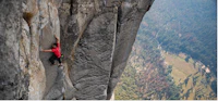 a man is climbing on the side of a mountain