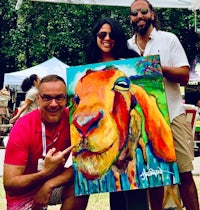 a group of people posing with a painting of a goat