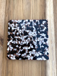 a black and white marble coaster on a wooden table
