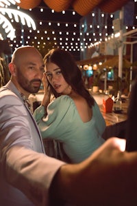 a man and woman taking a selfie at a bar