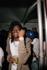 a man in a hat with a drink in his hand