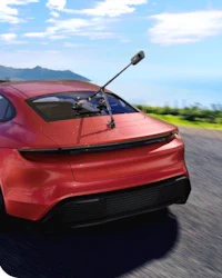 a red sports car is driving down the road