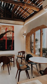 a dining room with a large painting on the wall