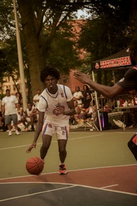 two men playing basketball in a park