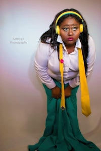 a woman in a yellow shirt and tie is posing for a photo