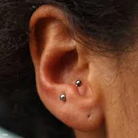 a close up of a woman's ear with piercings
