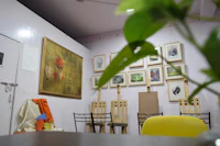 a room with a yellow chair and paintings on the wall
