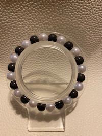 a black and white bead ring on a clear surface