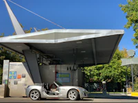 a silver sports car parked at a gas station