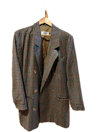 a brown and blue checkered blazer hangs on a hanger