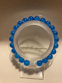 a clear plastic holder with blue beads on it