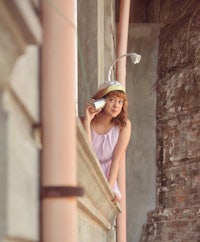 a woman is leaning on a railing while holding a cell phone