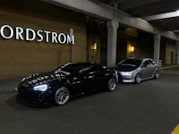 two cars parked in front of a building at night