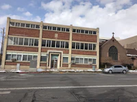 a brick building with a car parked in front of it