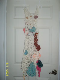 a crocheted dress hanging on a door