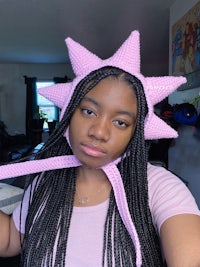 a young woman wearing a pink star hat