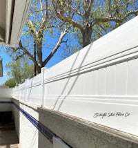 a white fence next to a pool