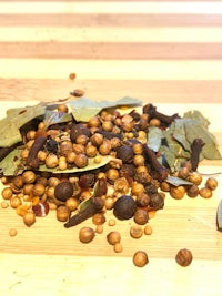 a pile of herbs and spices on a wooden table