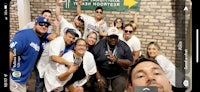 a group of people posing for a photo in front of a brick wall