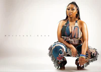 a woman is crouching down in front of a white background