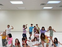 a group of children posing for a photo in a dance studio