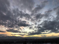 the sun is setting over a city with snow on the ground
