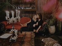two people sitting on a couch in a dark room
