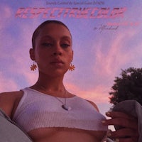 a woman in a white top is posing in front of a sunset