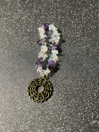 an amethyst and quartz bracelet on a black surface