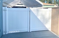 a white fence with a white gate in front of it