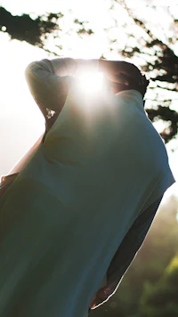 a person is holding a kite in the sun