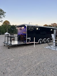a black enclosed trailer parked in a gravel lot