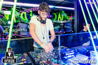a man is djing at a club with neon lights