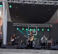 a group of people playing music on stage in front of green lights