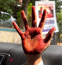 a person's hand with red paint on it