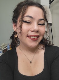 a woman is smiling while taking a selfie in a bathroom